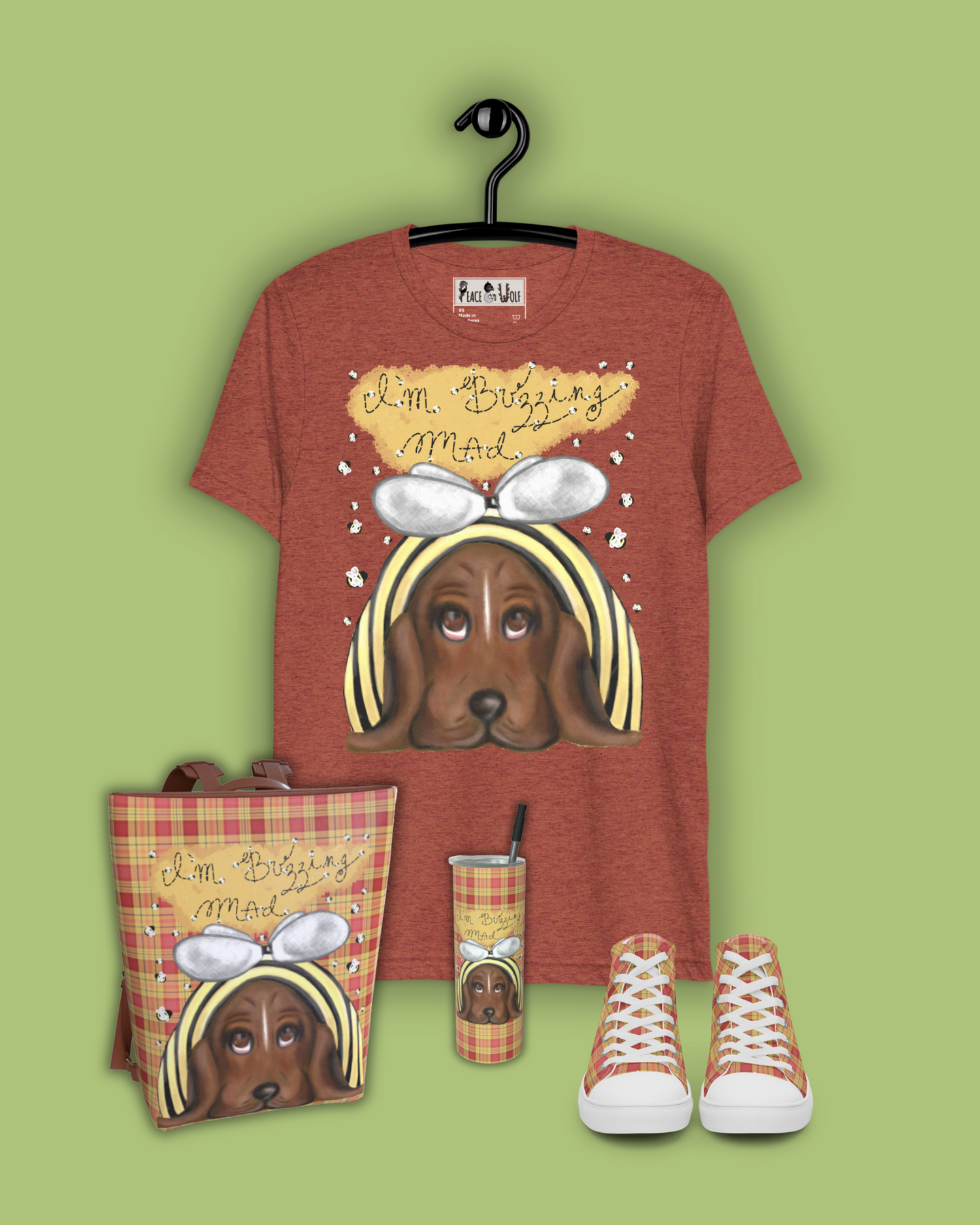 A basset hound in a bumble bee costume with sad, drooping eyes stares up at you from this adorable t-shirt. Bumble bees surround the dog, and in letters made from dotted lines like the trails of bumble bees flying across are the words: "I'm buzzing mad".